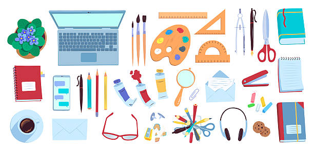 different creative items and utensils set out of a desk with headphones, a laptop and glasses