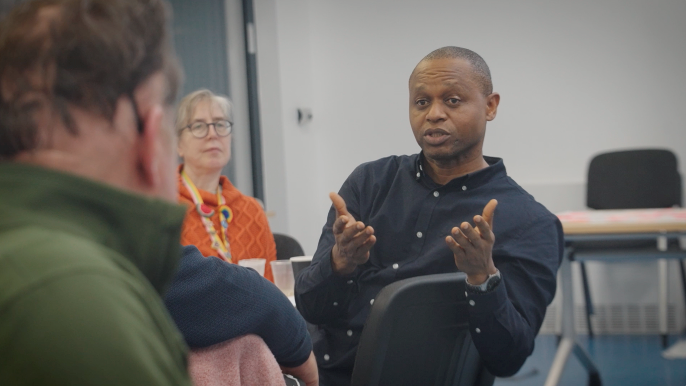 Workshop participants facing towards another person across the room talking